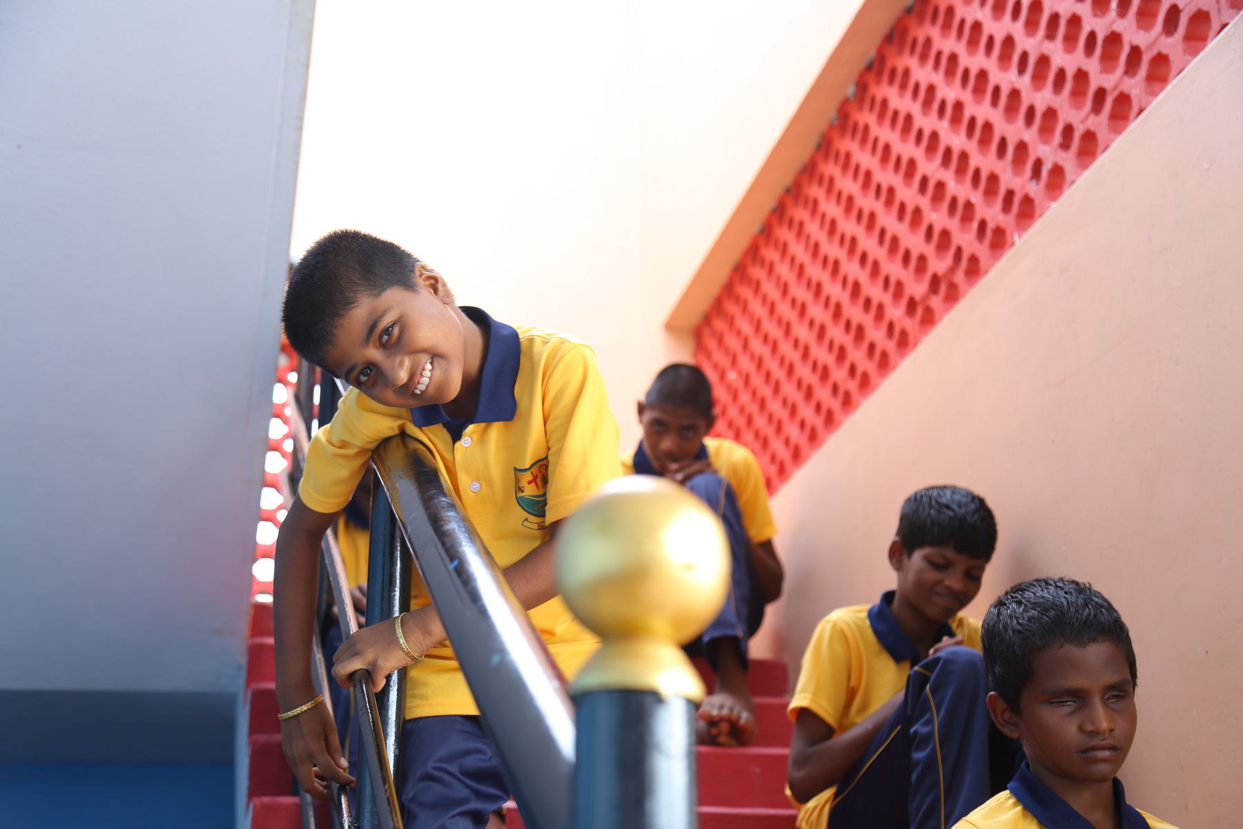 Children smiling on the stairs of the home
